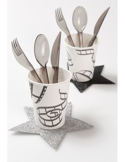 Scéna se stolním nádobím a podtácky ve tvaru hvězd s papírovým kelímkem s filmovým motivem