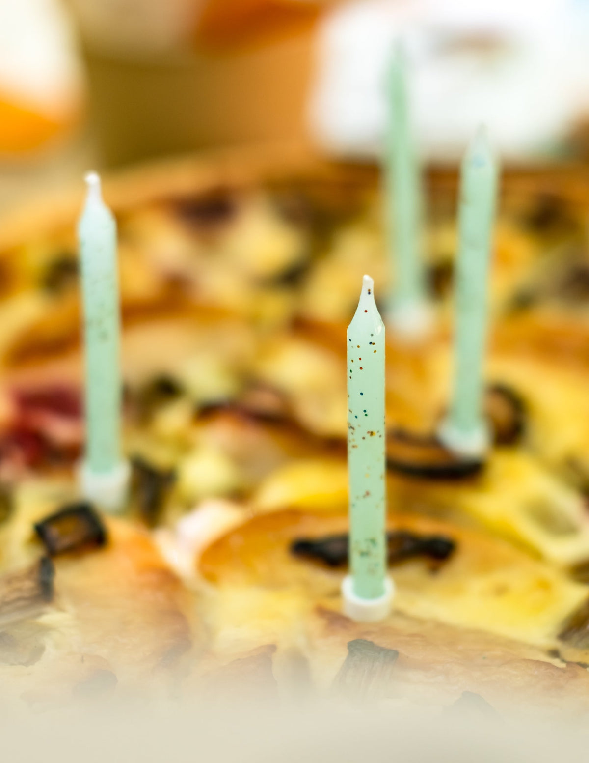 Focus sur la disposition sur un gâteau des bougies menthe à paillettes pour anniversaire