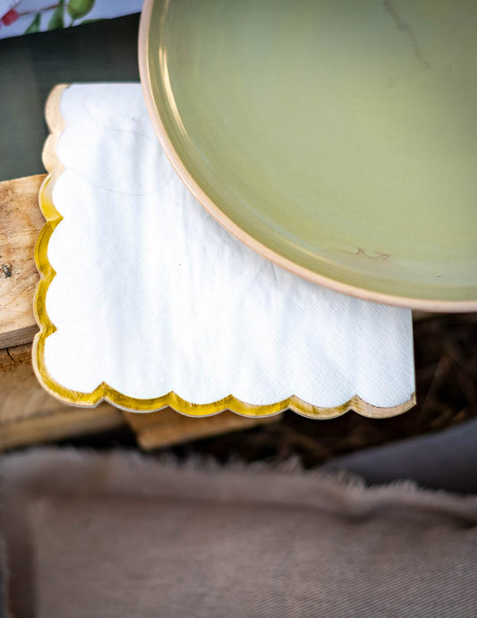 Gros plan sur la finition dorée des serviettes festonnées élégantes blanches à bords dorés