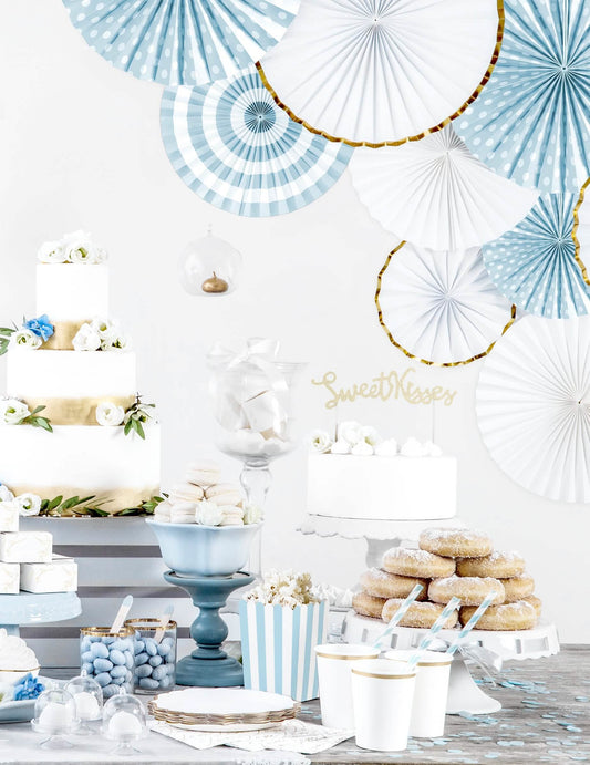 Mise en situation sur un buffet de fête des 3 rosaces en papier blanches et dorées pour décoration