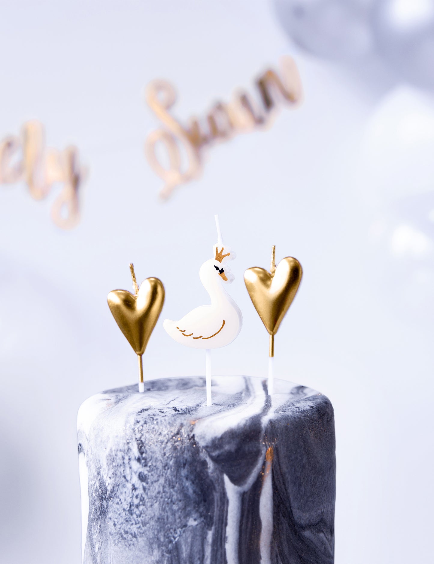 Gros plan des bougies sur pic cygnes et cœurs pour anniversaire