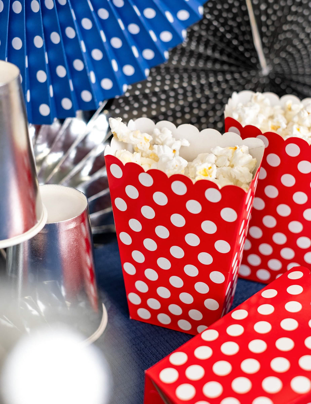 Detailní záběr na červená popcornová kelímky s bílými puntíky na oslavu