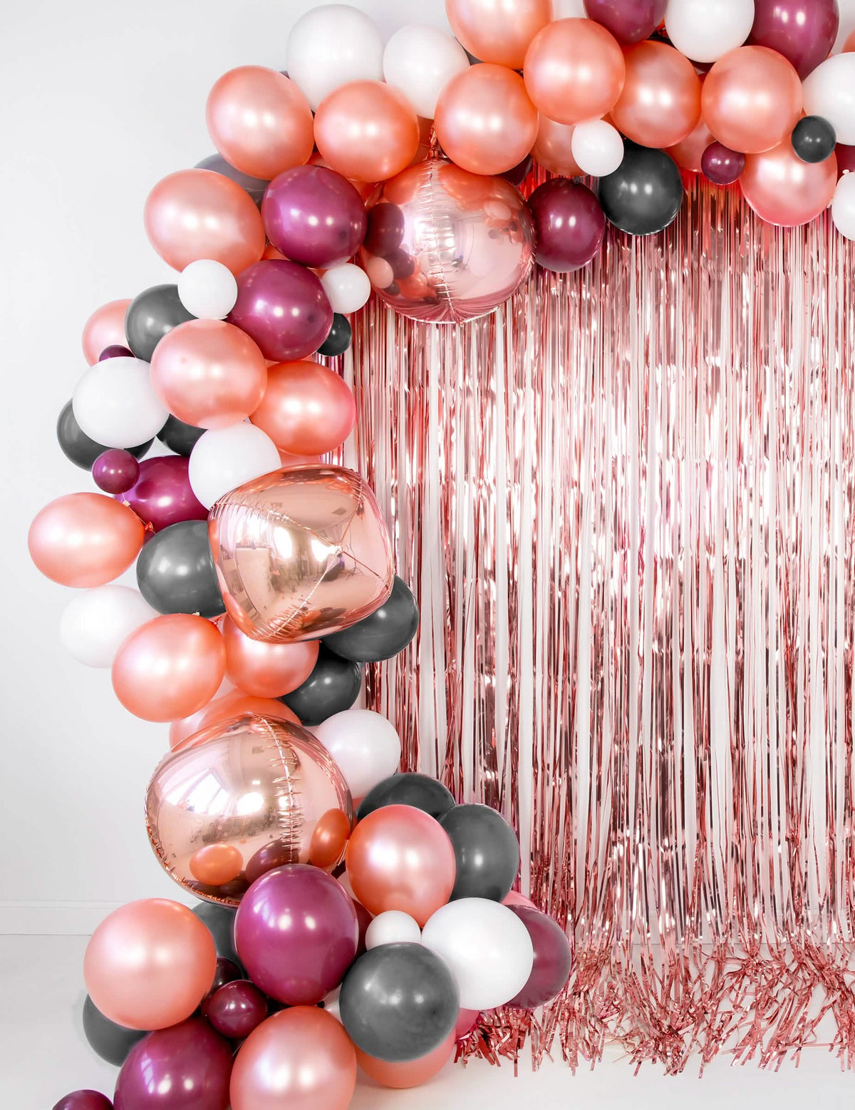 Oblouk z balónků a třásňová záclona z metalického balónu ve tvaru koule z růžového zlata