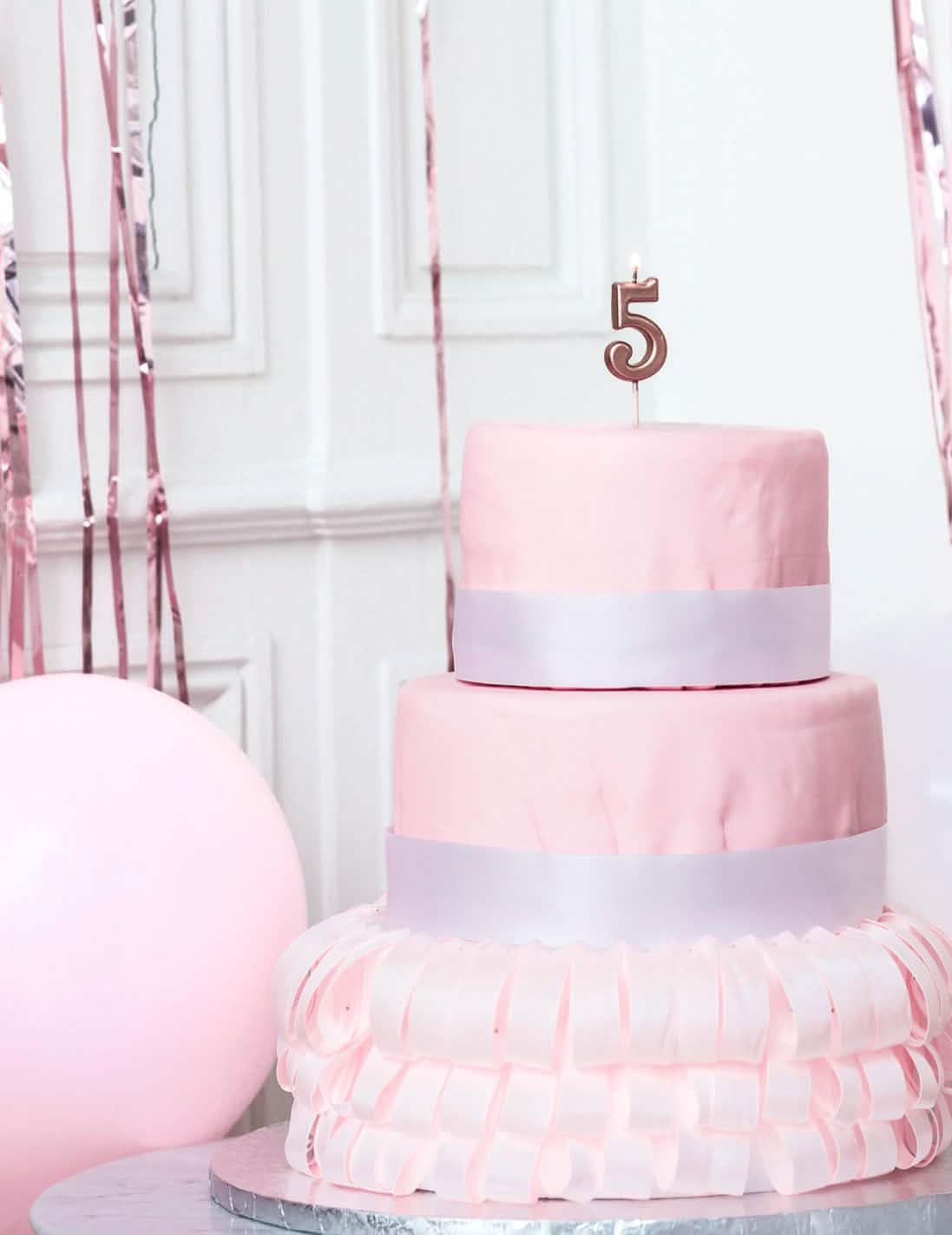 Mise en situation sur un gâteau de la bougie d'anniversaire chiffre 5 rose gold métallisé