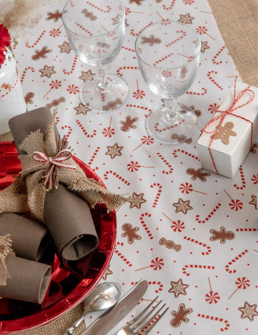 Mise en situation sur une table du chemin de table gourmandises de Noël blanc festif