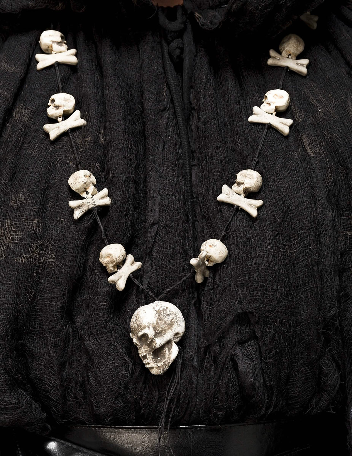 Détail du collier avec têtes de mort et os du déguisement sorcier occulte avec masque luxe