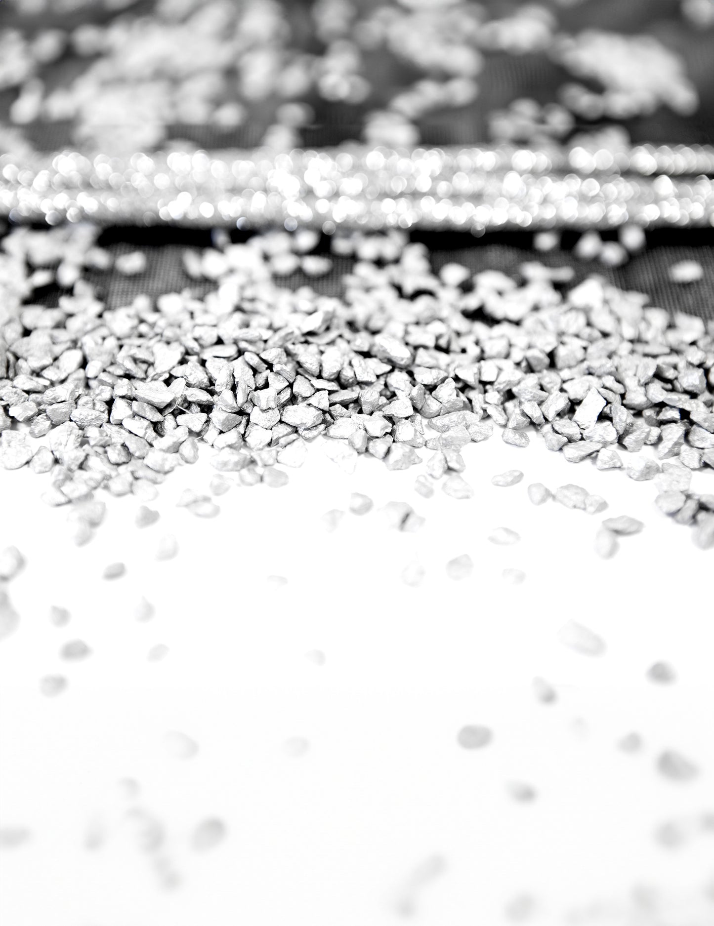 Detailní pohled na texturu stříbrných kamínků na dekoraci oslavy