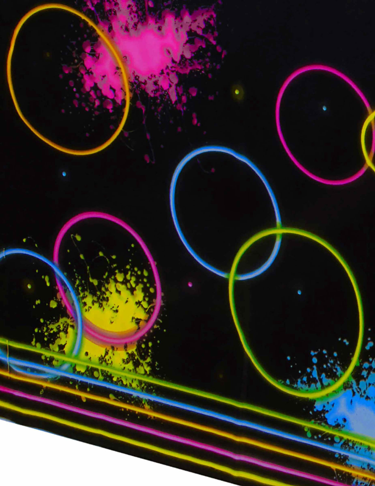 Detail na neonové kruhy a skvrny na černém plastovém ubrusu Glow Party