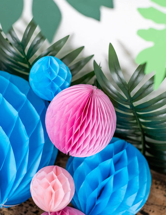 Mise en situation tropicale de la boule en papier alvéolé décoration à suspendre rose