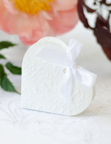 Boite à dragées en carton cœur pour mariage blanc avec arabesques et ruban satiné