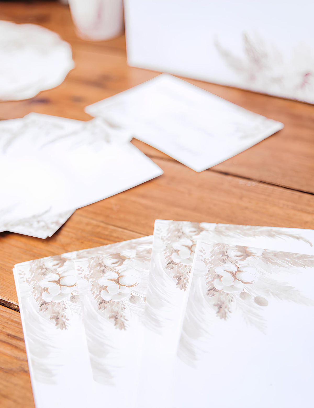 Détail du motif floral des invitations avec enveloppes pampas et fleurs de coton