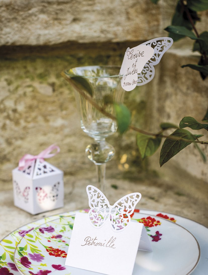 Mise en scène sur une table de fête du marque-places papillons dentelles