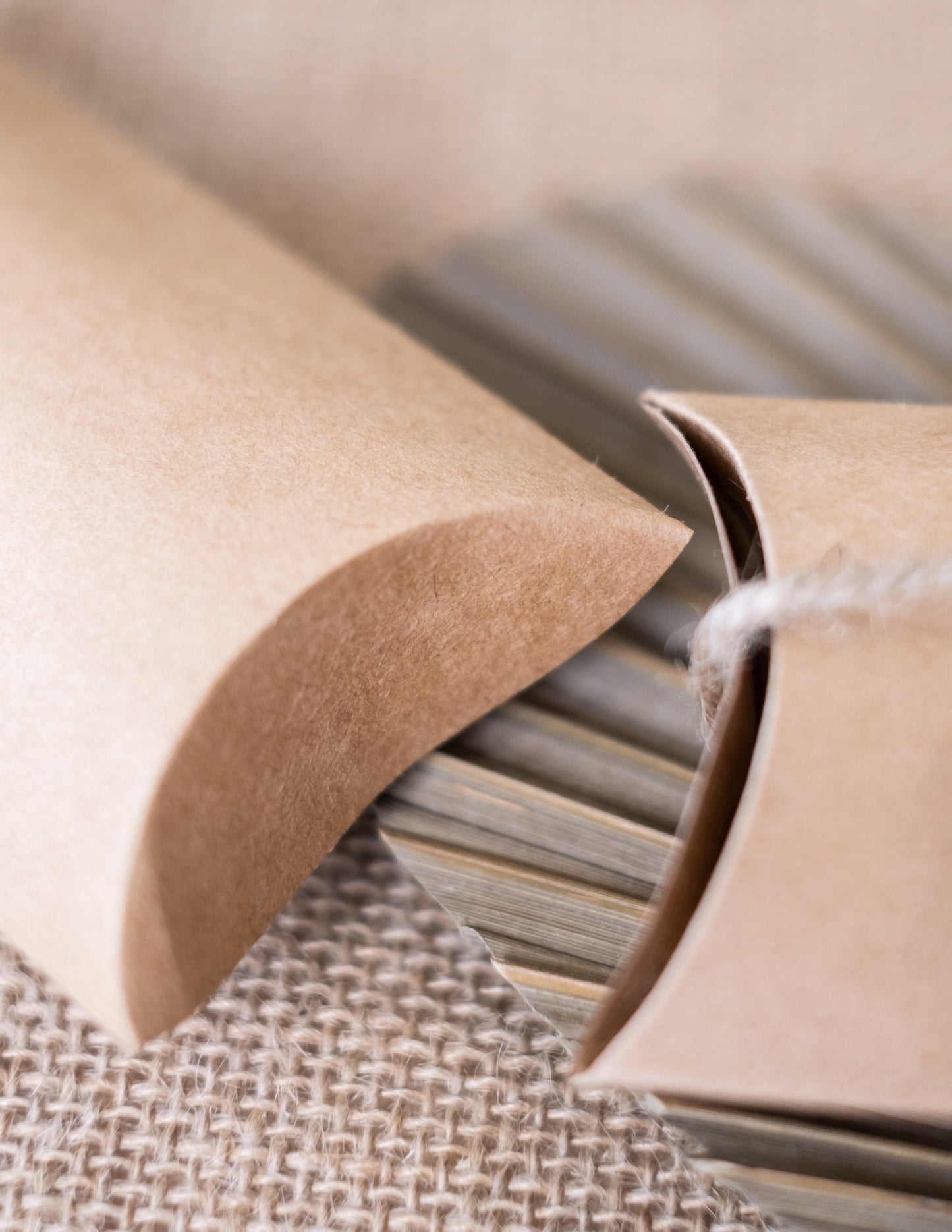 Detailní záběr na skládání malých kraftových krabiček na oslavu světle hnědé ve tvaru berlingotu