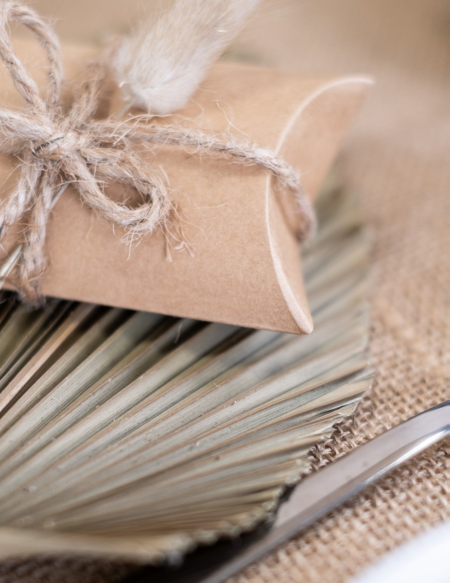 Detail dekorativního provázku malých kraftových krabiček na oslavu světle hnědé ve tvaru berlingotu