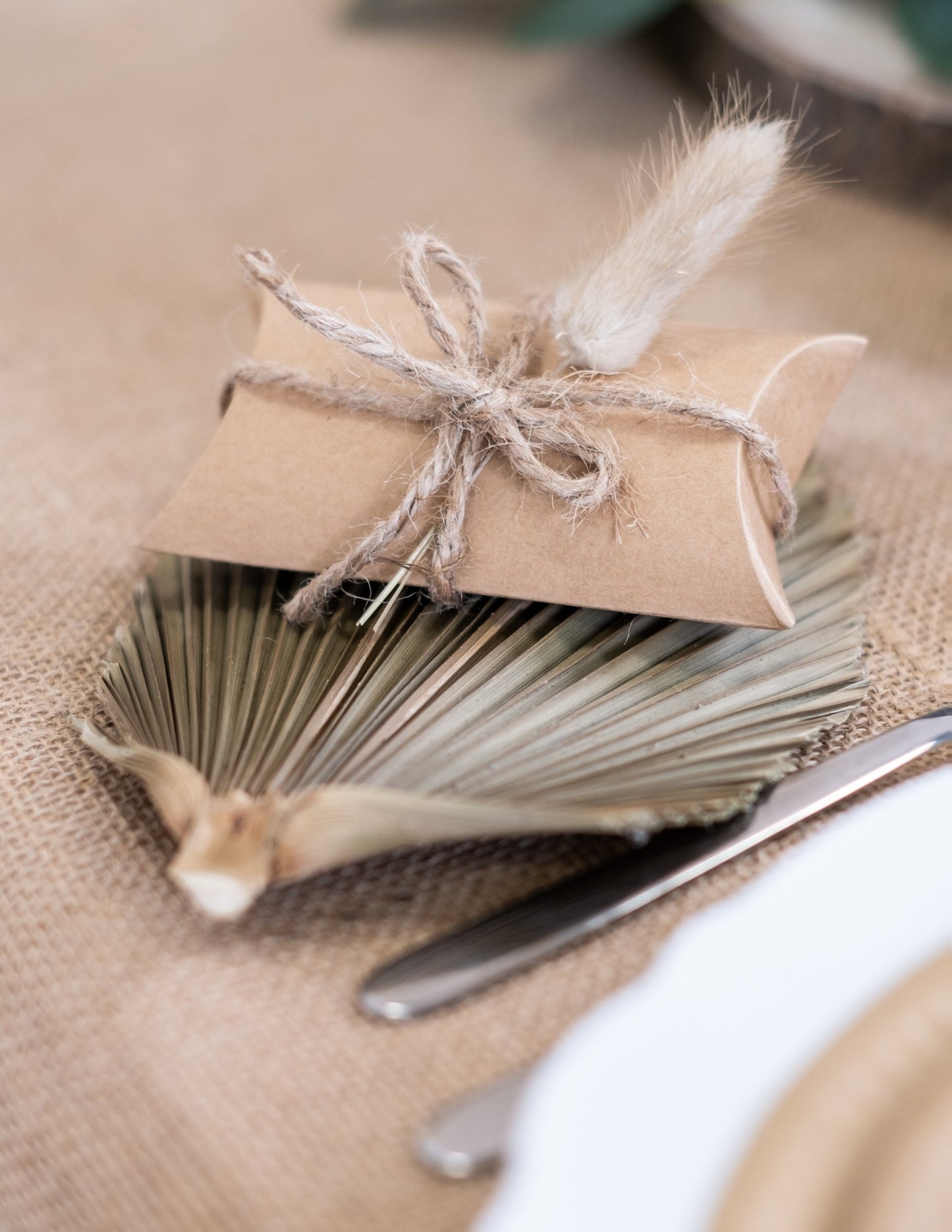 Detail rostlinné ozdoby malých kraftových krabiček na oslavu světle hnědé ve tvaru berlingotu