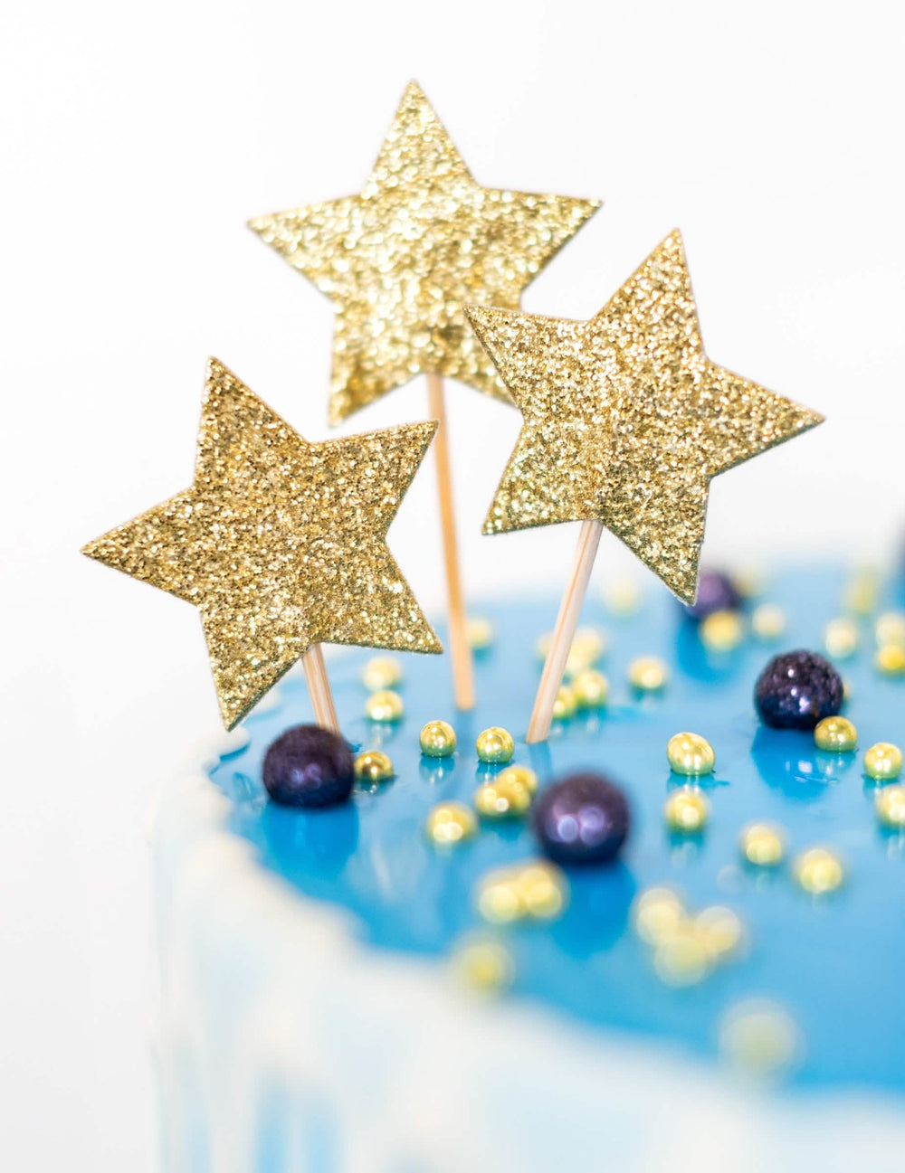 Detail na zlaté třpytky cake topperu na špejli hvězda pro narozeniny