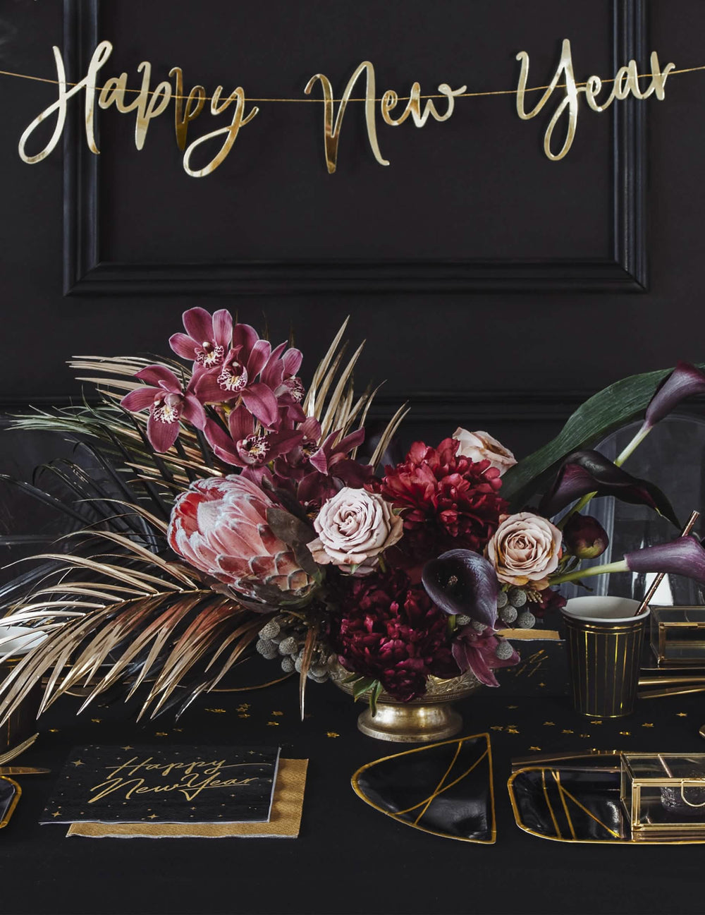 Prostření na slavnostní stůl s černými a zlatými papírové ubrousky Happy New Year s hvězdnou dekorací