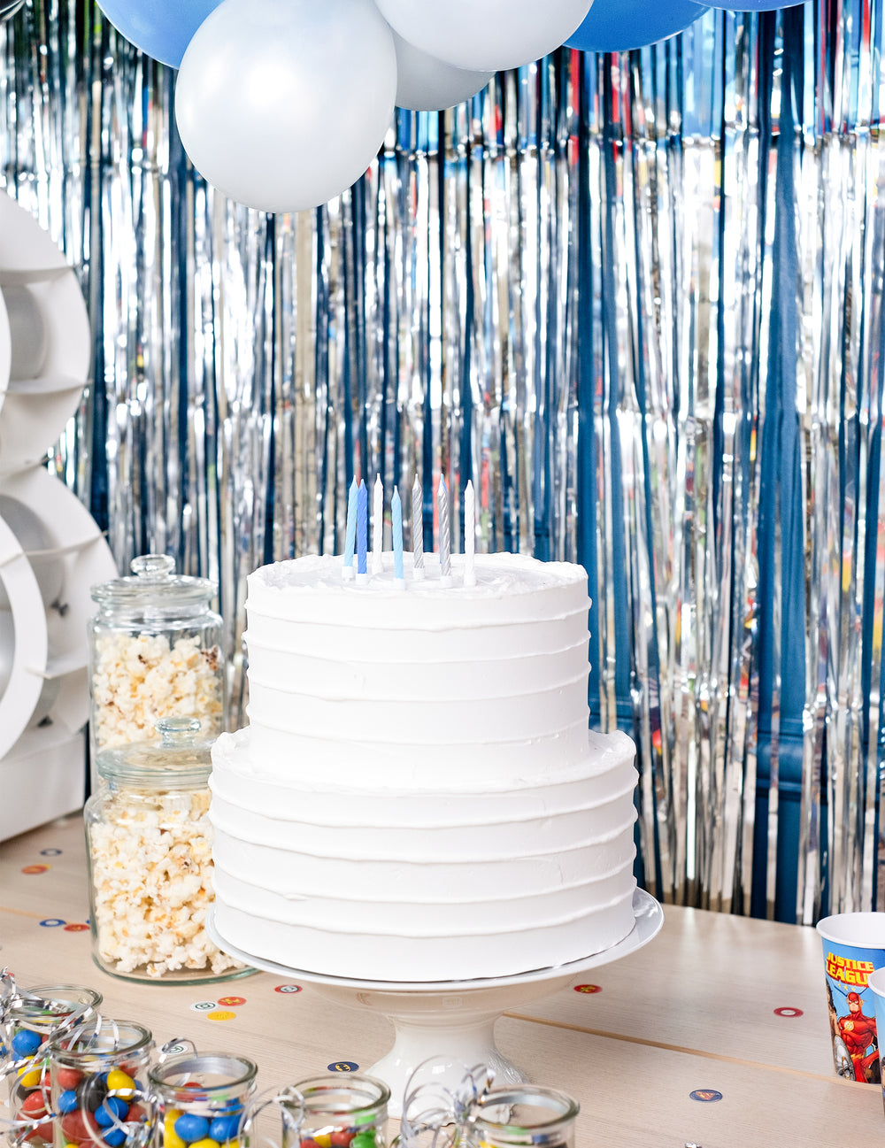 Mise en situation sur un gâteau des bougies d'anniversaire pour fête bleues blanches et argentées torsadées