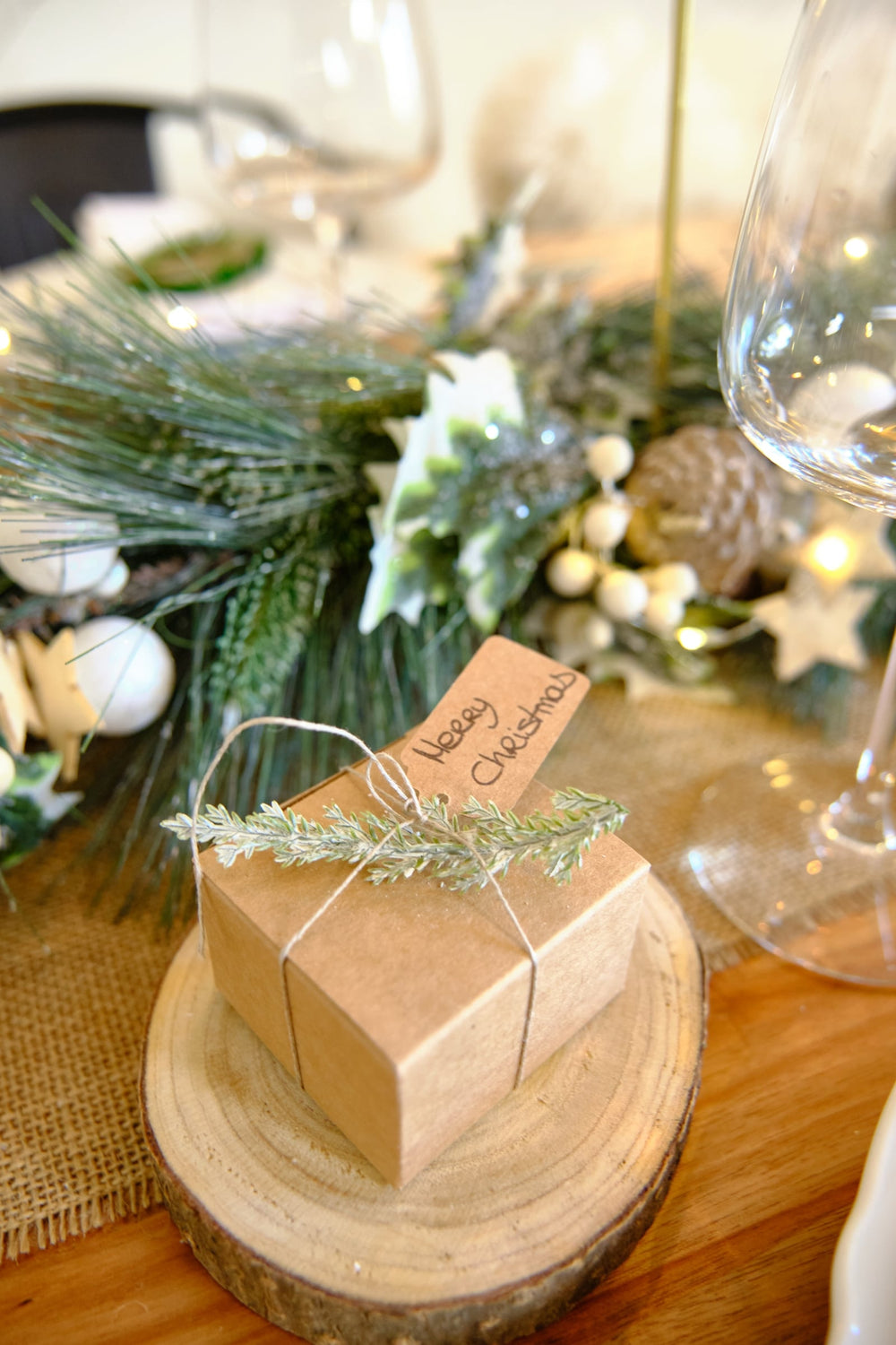 Détail de l'utilisation sur un cadeau des branches de cyprès artificielles enneigées pour décoration