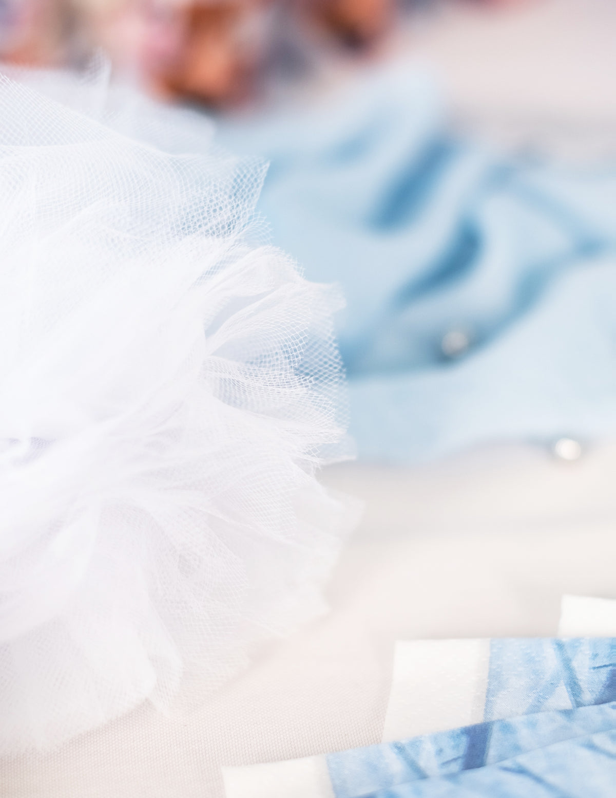 Gros plan sur la texture des pompons à suspendre en tulle pour décoration blancs