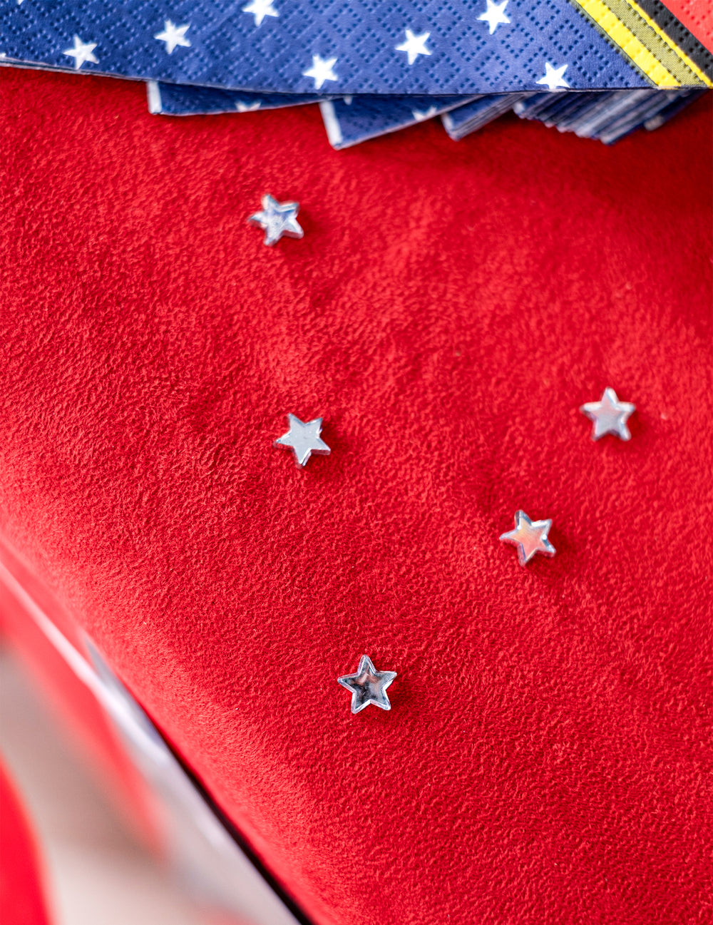 Vue de dessus des étoiles parsemées sur fond rouge du confettis de table étoiles miroir pour fête