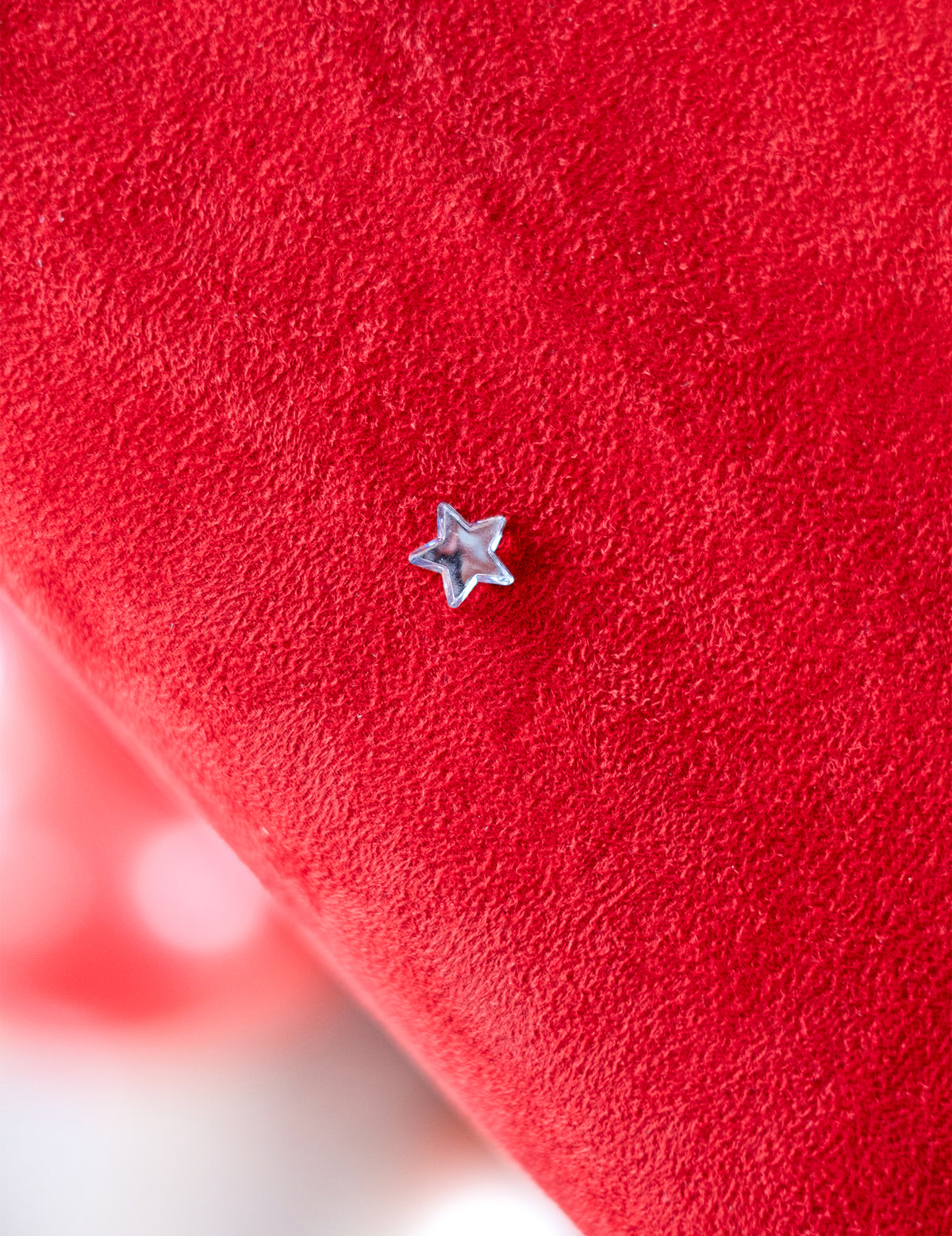 Gros plan d'une étoile sur fond rouge du confettis de table étoiles miroir pour fête