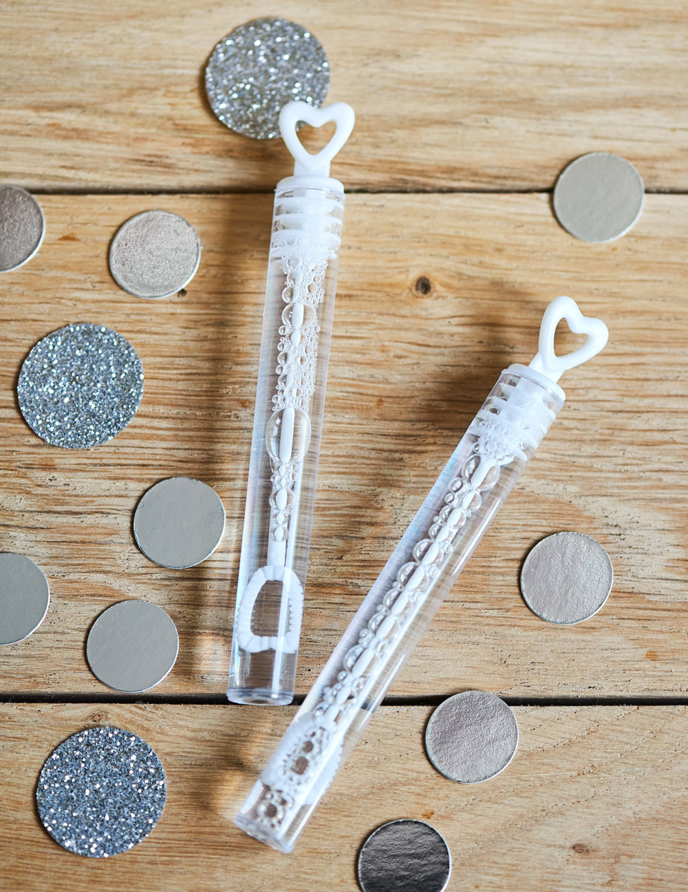 Détail avec confettis des flacons à bulles en forme de coeur pour mariage blanc
