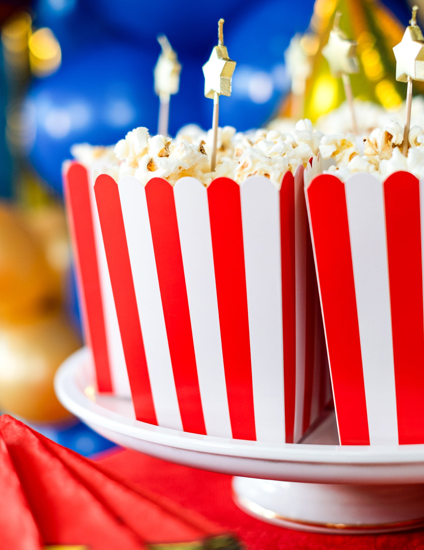 Gros plan sur le popcorn et les pics dorés des boîtes à popcorn en carton rouges et blanches