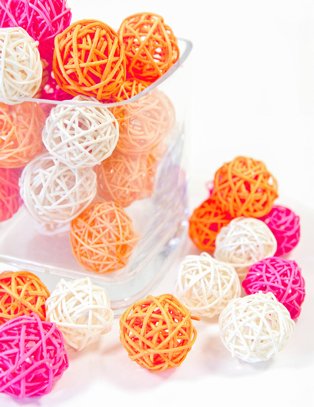 Mise en situation dans un vase en verre des boules en osier pour décoration fuchsia