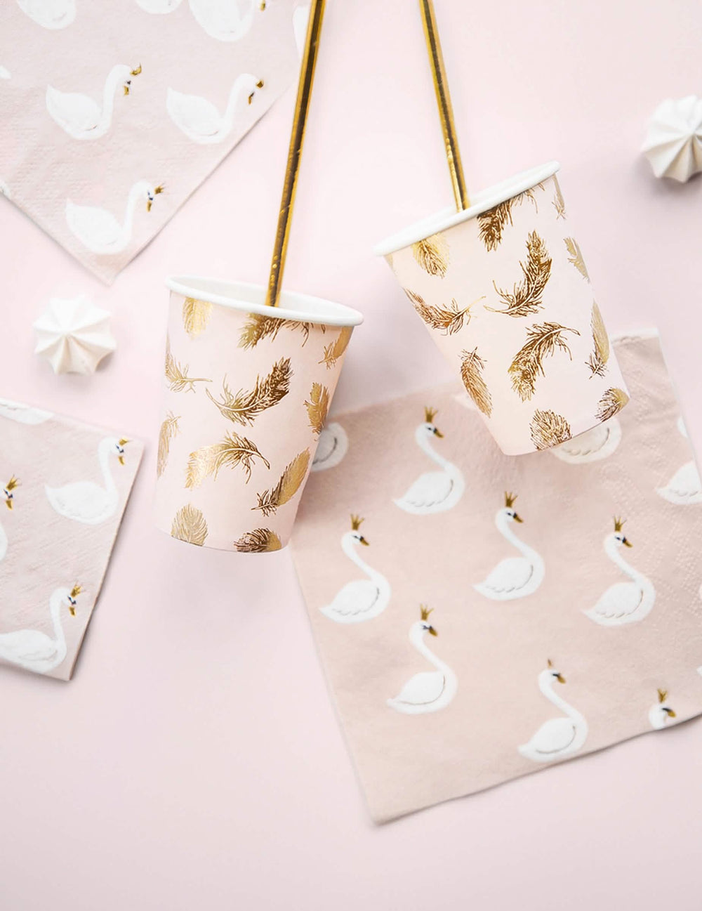 Scéna s ubrousky, papírovými kelímky, růžová lovely swan a zlatými peříčky