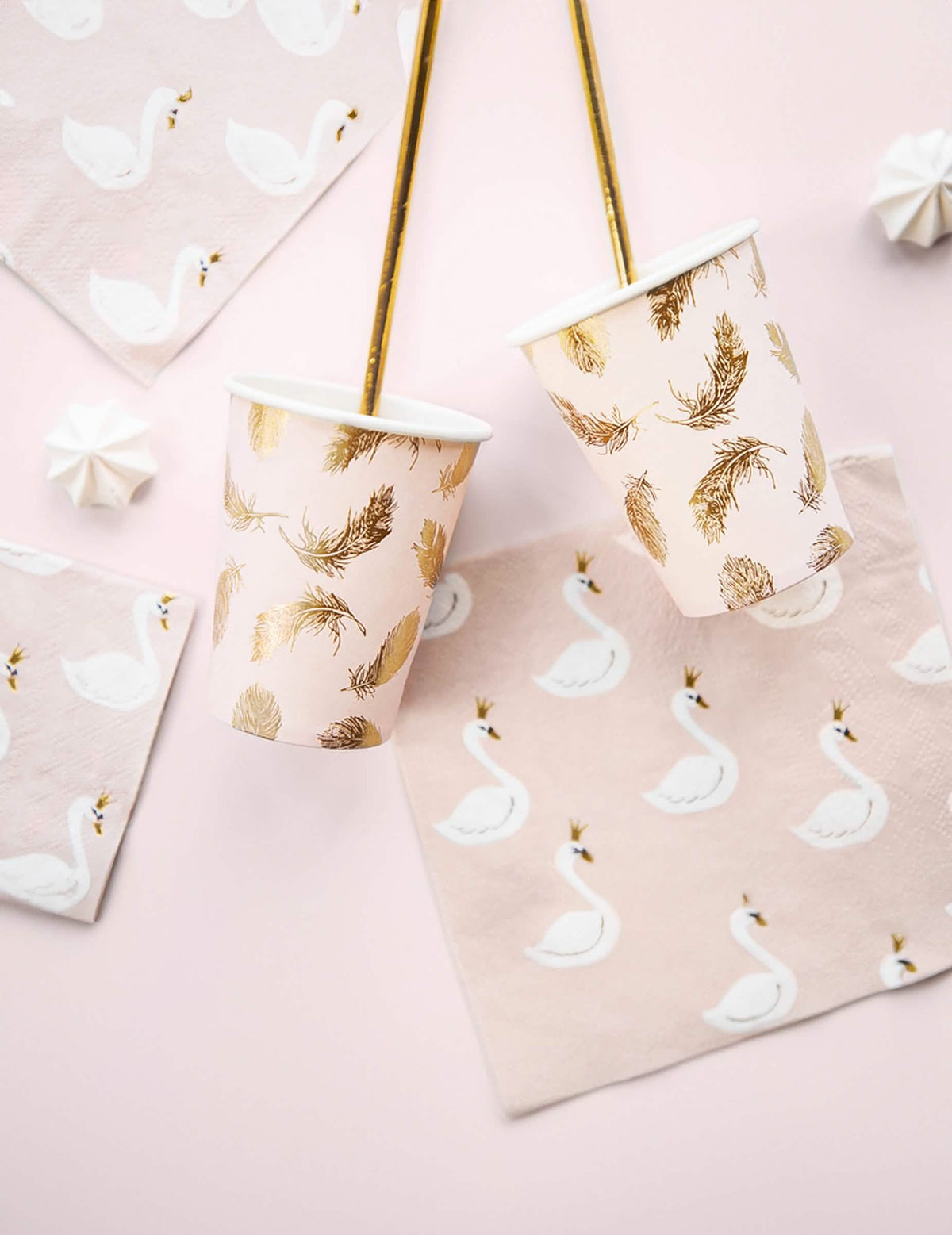 Scéna s ubrousky, papírovými kelímky, růžová lovely swan a zlatými peříčky
