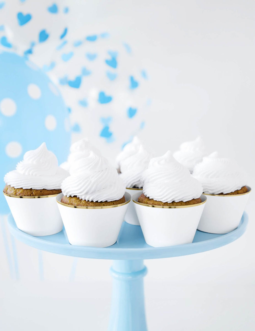 Pódium s modrými balónky a papírovými zápichy do cupcakes na svatbu
