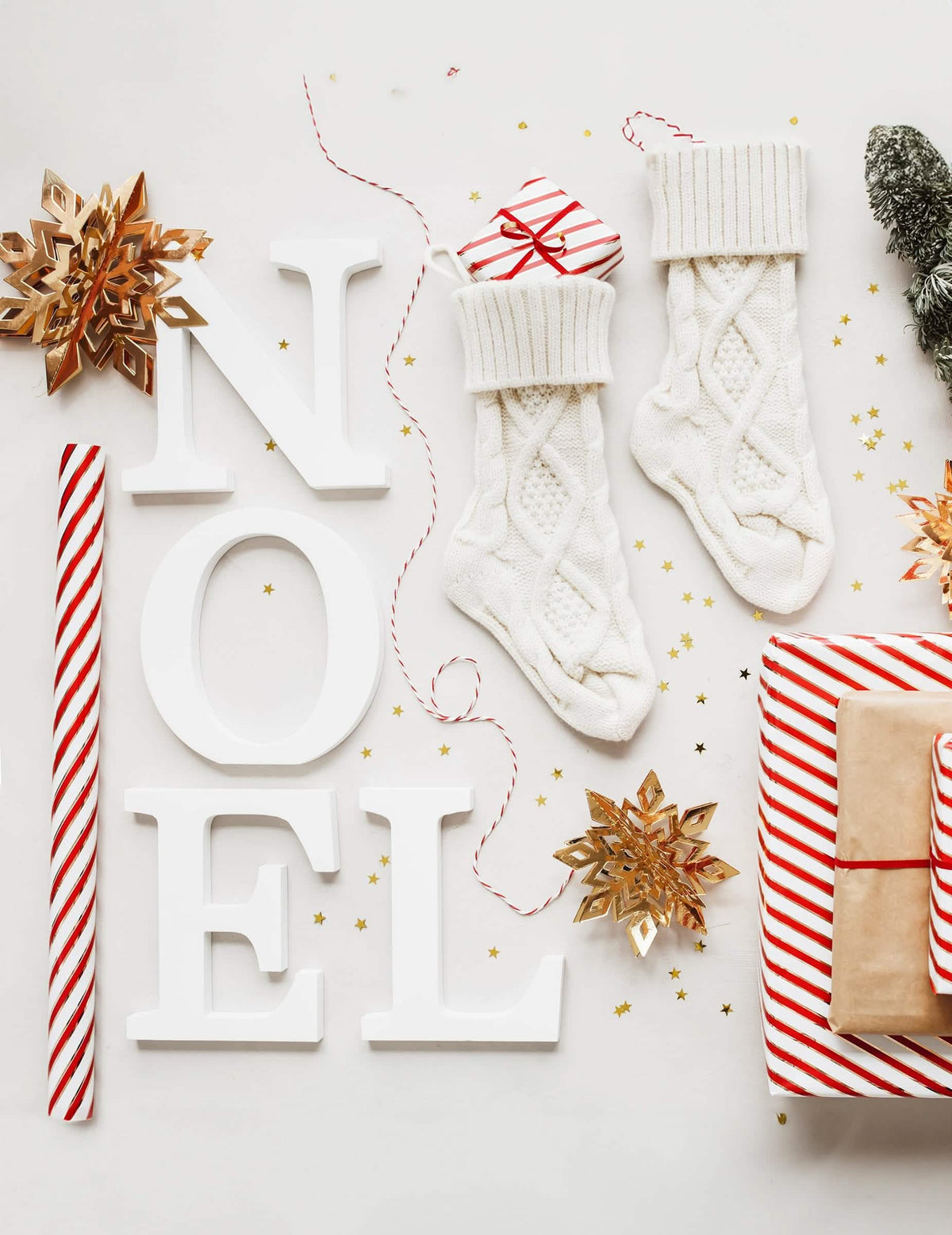 Výzdoba s písmeny NOEL zavěšenými kartonovými zlatými sněhovými vločkami