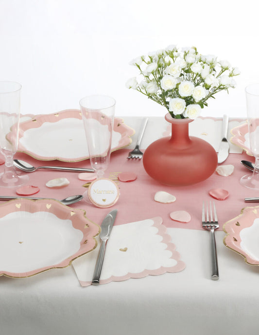 Mise en situation sur une table de fête des pétales en satin pour décoration ivoire rose et vieux rose