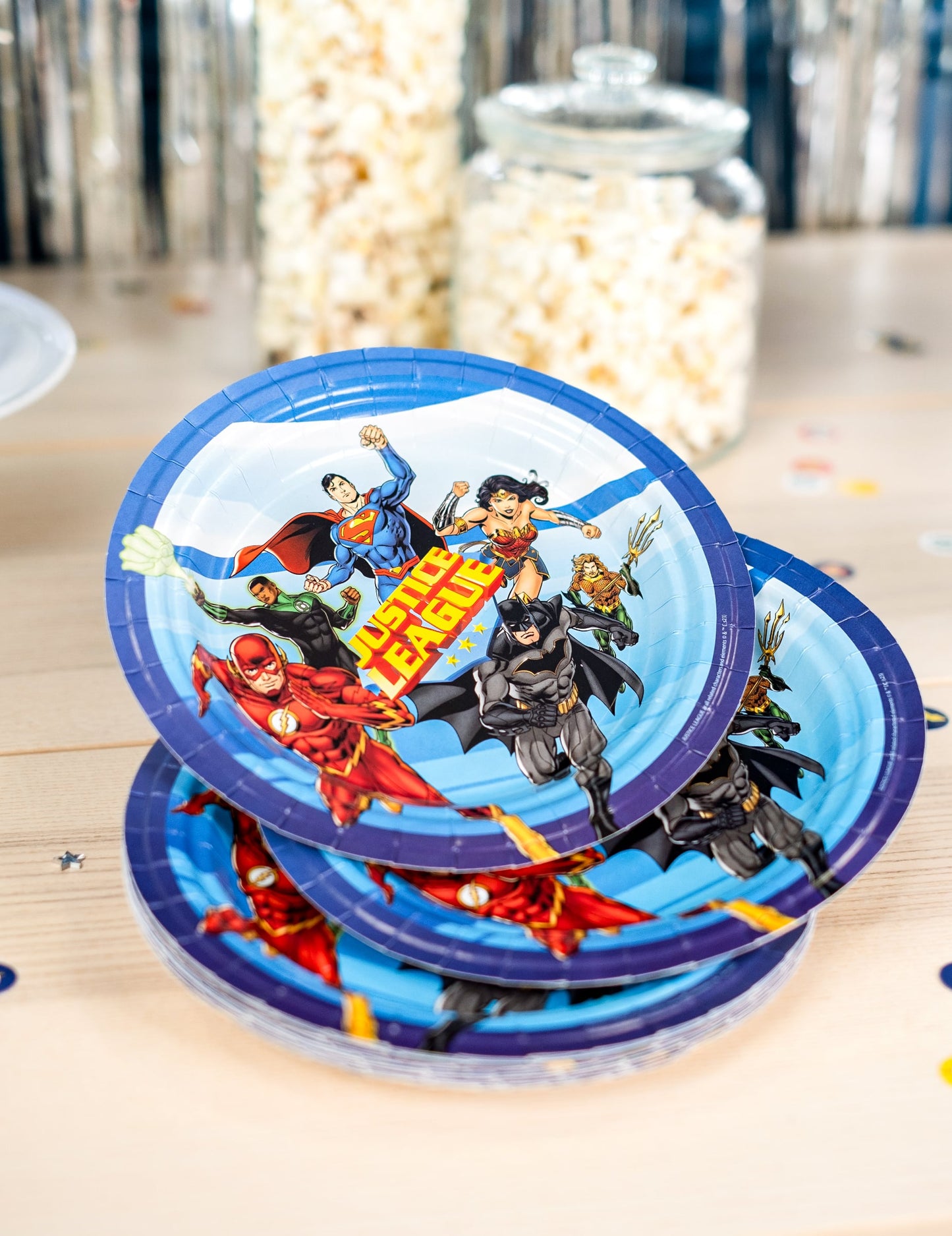 Mise en situation sur une table avec pop-corn des assiettes en carton Justice League