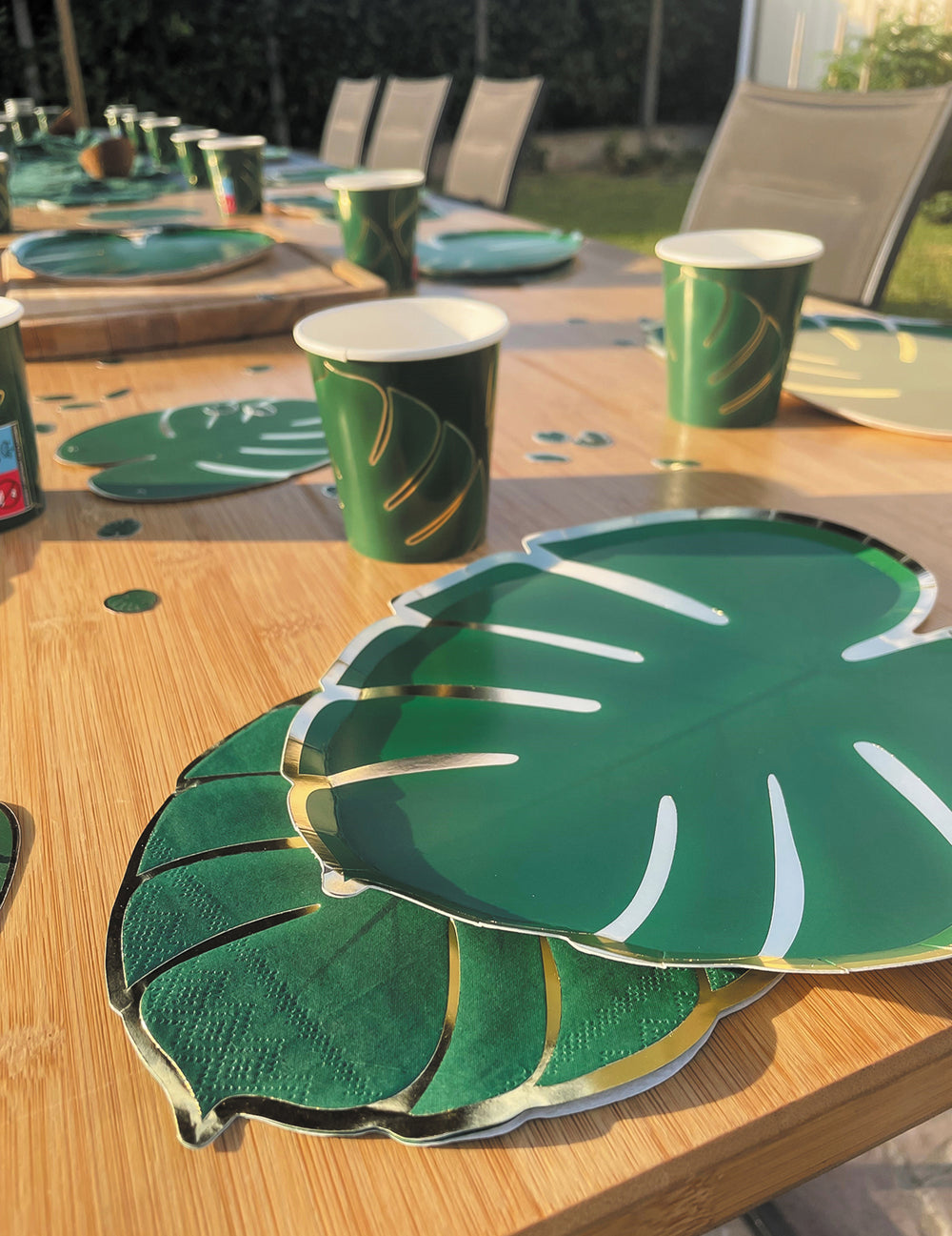Vue rapprochée de la table de fête des assiettes en carton feuilles tropicales