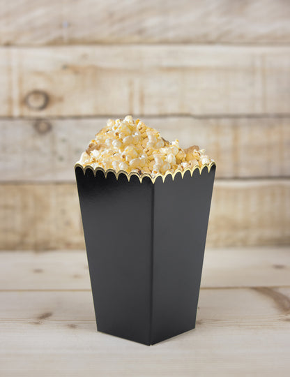 Gros plan d'une boîte remplie des boîtes à pop-corn festonnées pour fête noires et or