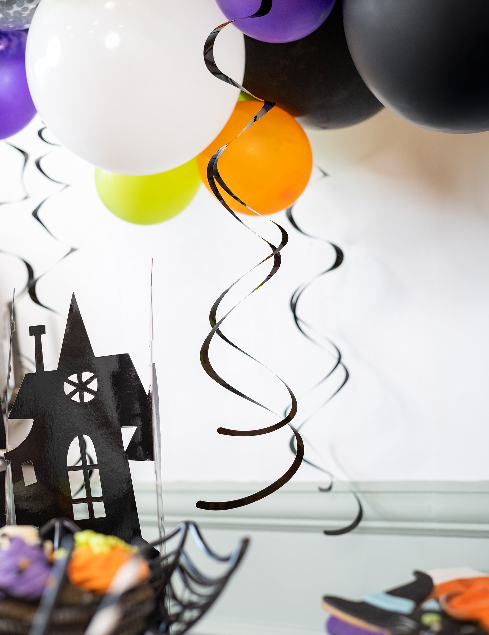 Veselá scéna s černými spirálovými závěsnými dekoracemi