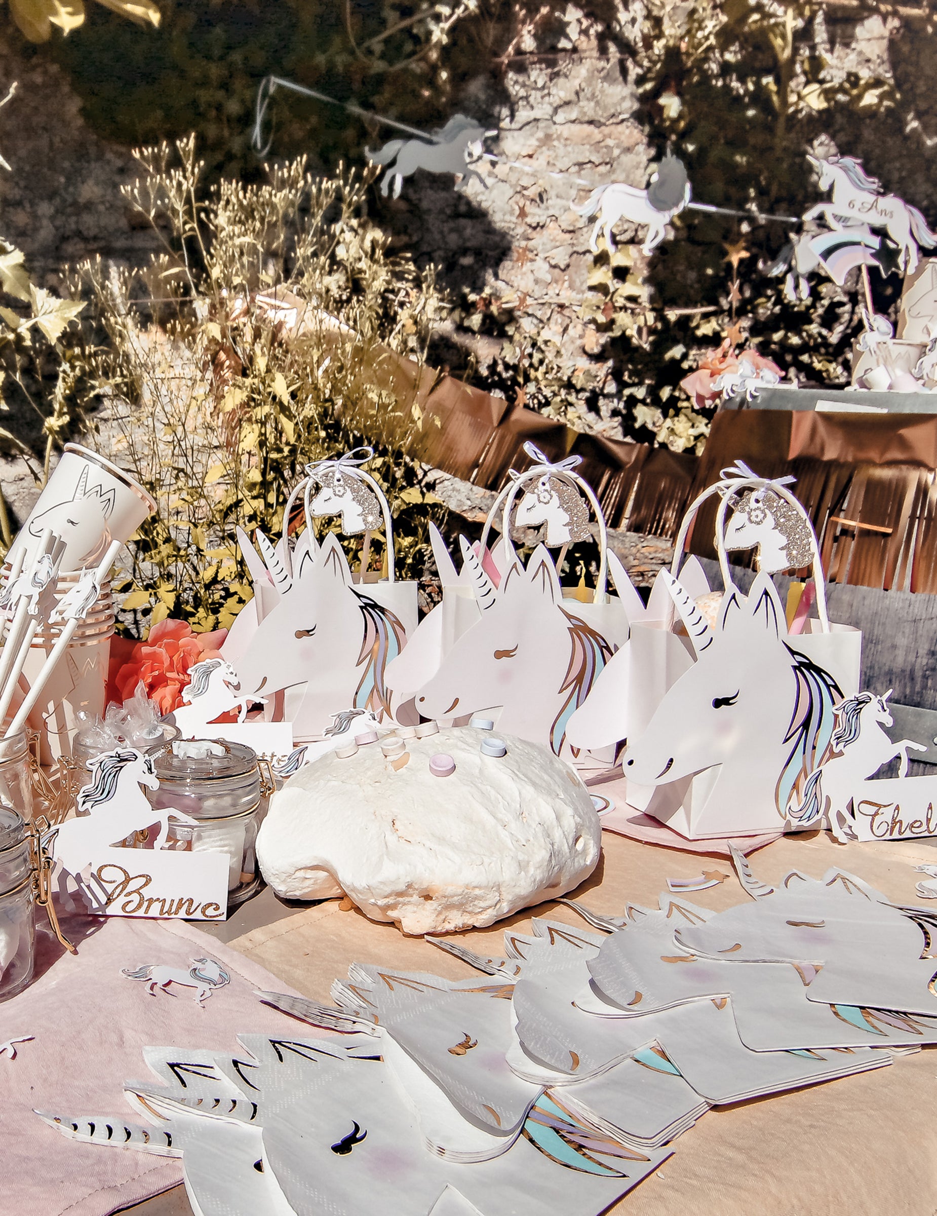 Mise en situation sur une table de fête des étiquettes licorne pour fête champagne pailleté