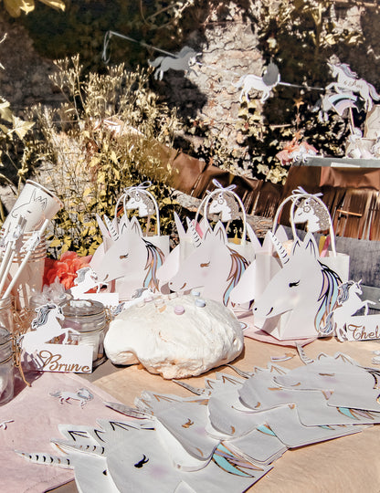 Mise en situation sur une table de fête des étiquettes licorne pour fête champagne pailleté