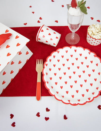 Mise en situation sur une table de fête des gobelets en carton petits cœurs