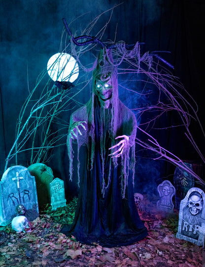 Mise en situation de l'arbre hanté articulé lumineux et sonore Halloween dans un décor de cimetière