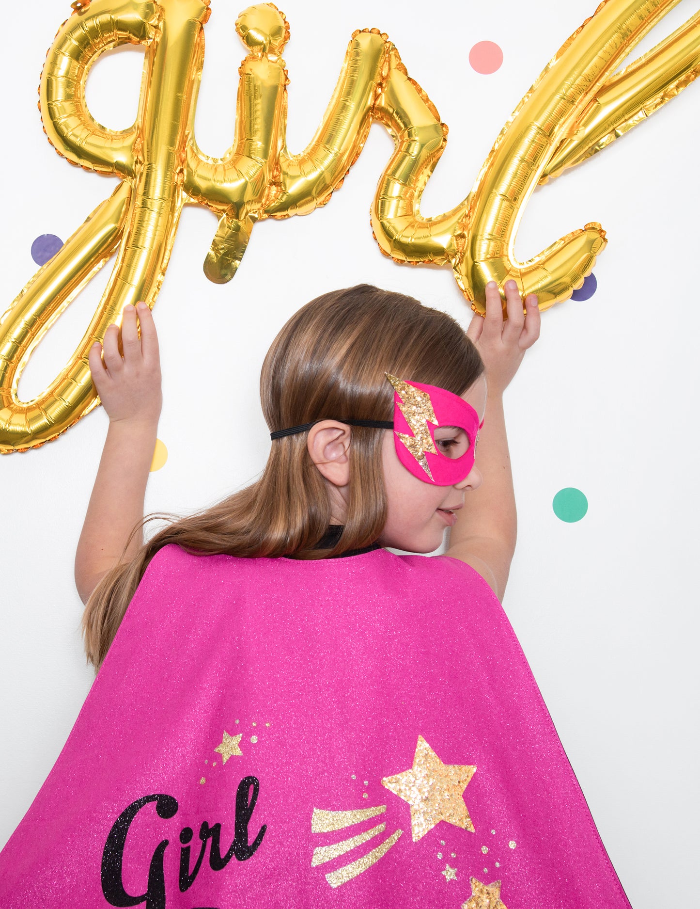 Vue de dos du ballon aluminium girl doré tenu par une enfant