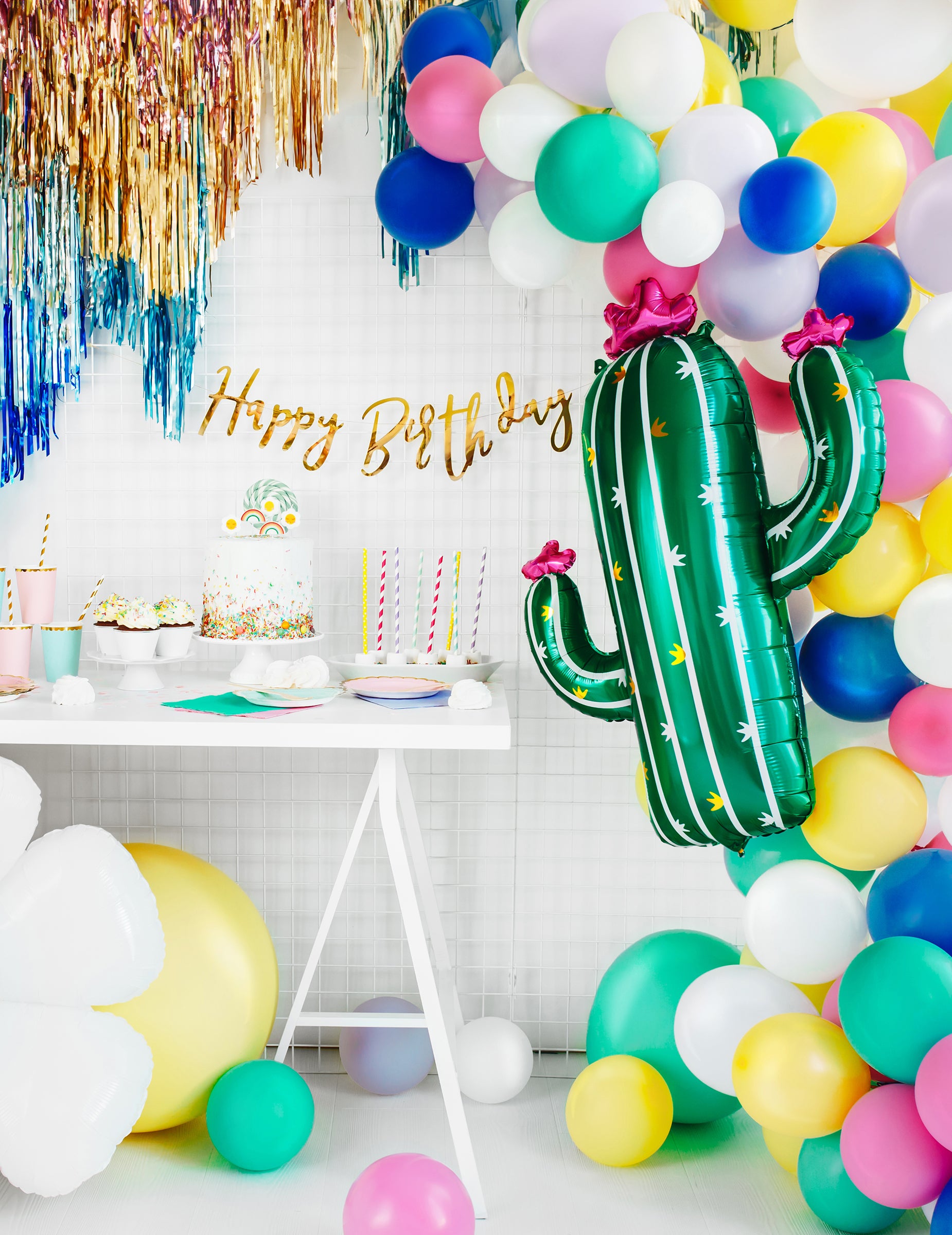 Mise en scène de fête d'anniversaire avec buffet et arche de ballons du ballon cactus en fleurs