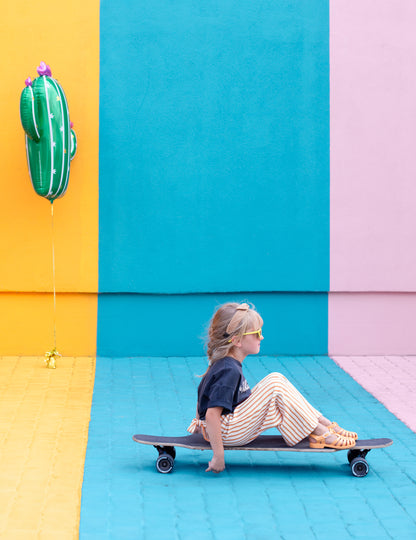 Mise en scène avec enfant sur un skateboard du ballon cactus en fleurs