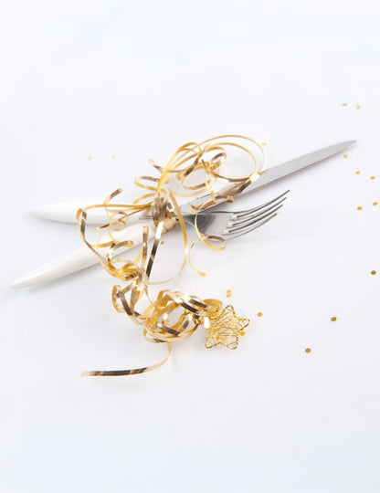 Mise en situation sur des couverts du Bolduc brillant pour décoration de fête or