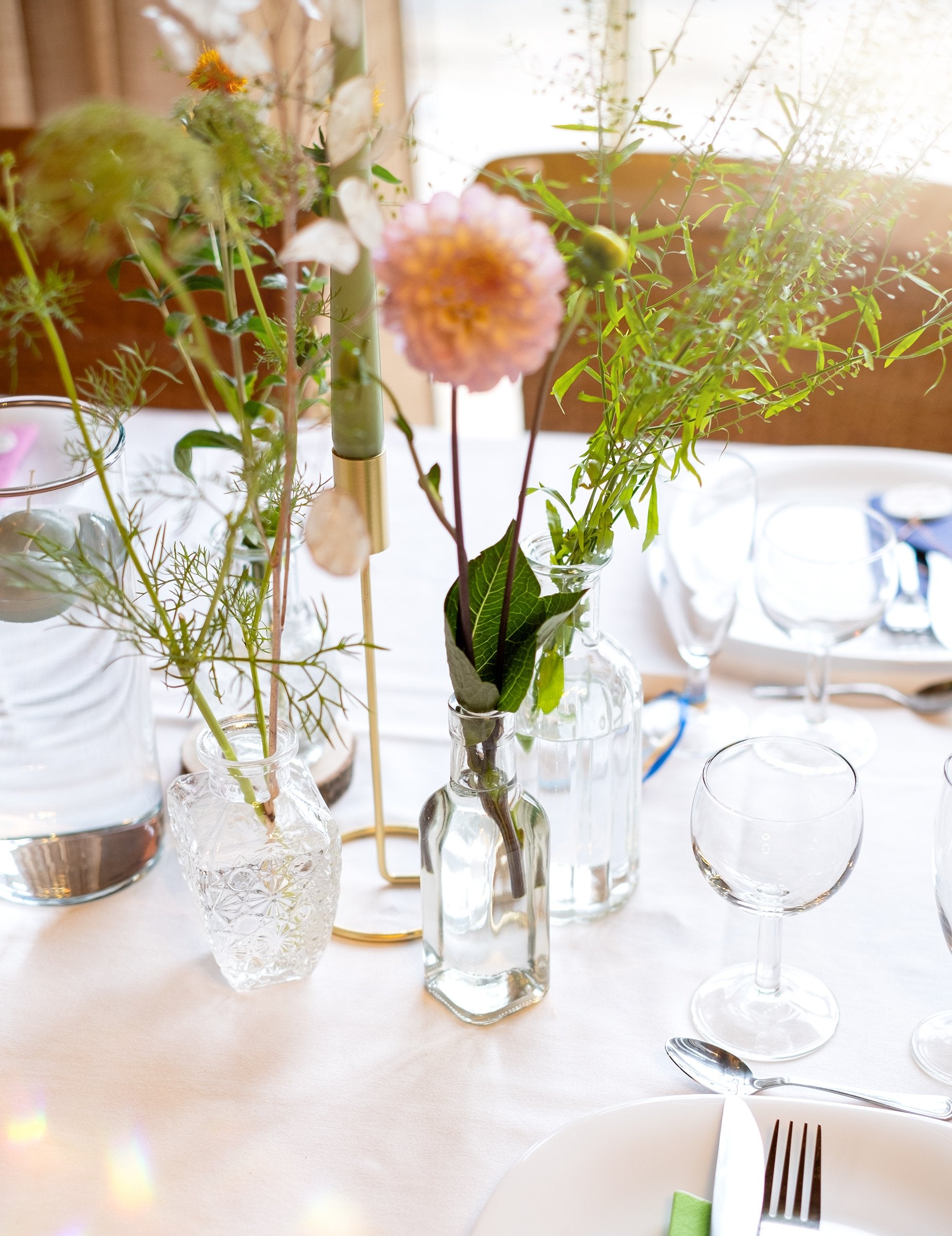 Situace na slavnostním stole se skleněnou čtvercovou láhví pro dekoraci