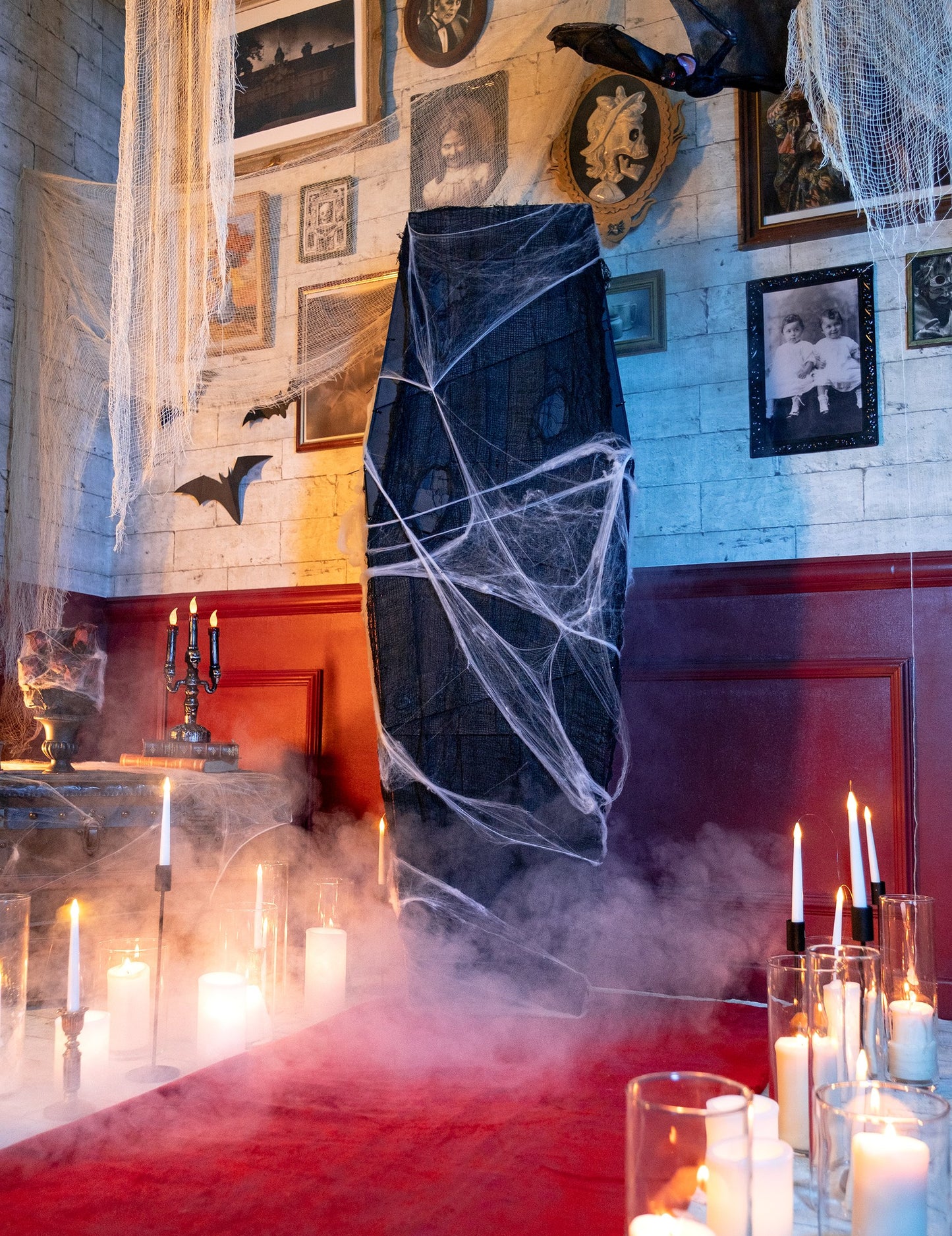 Scéna se svíčkami a kouřem u halloweenské rakve na dekoraci s bílou pavučinou