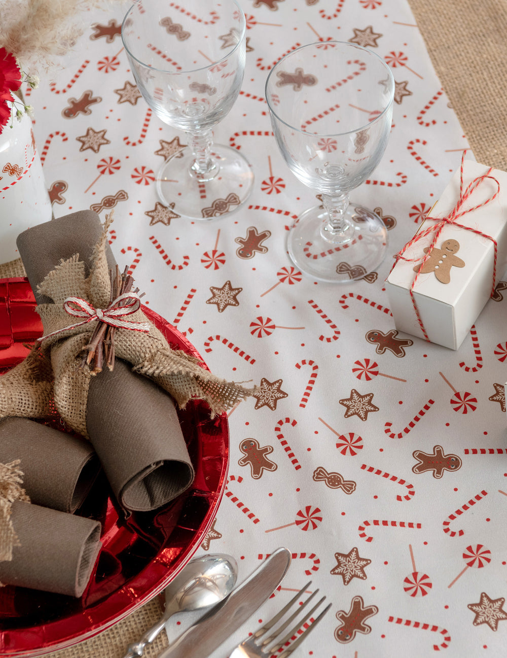 Mise en situation sur une table du chemin de table gourmandises de Noël blanc festif