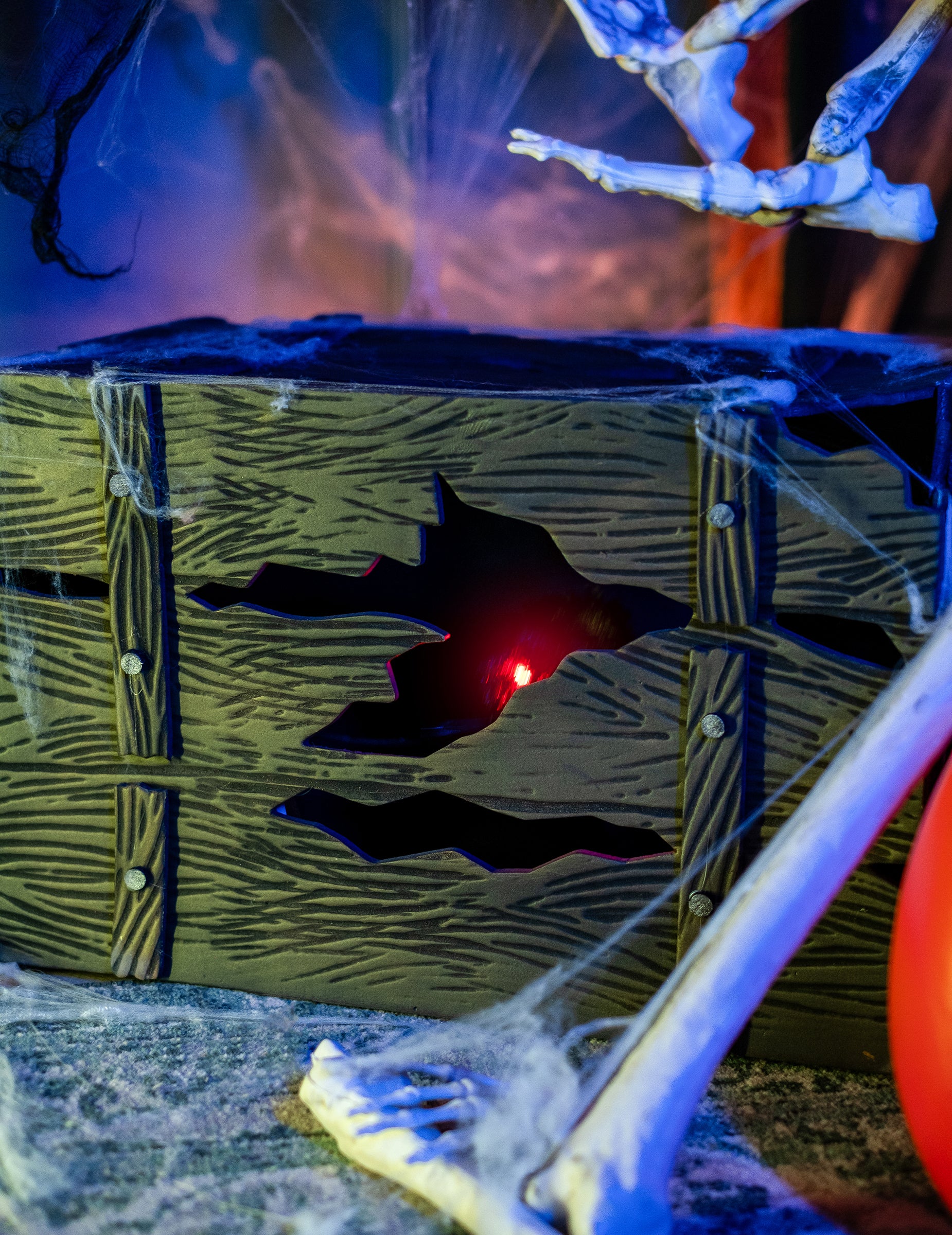 Gros plan sur la lueur rouge à travers le bois du coffre lumineux et sonore avec créature cachée